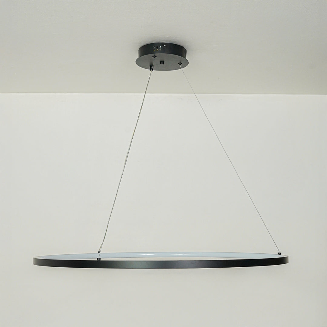 Modern slim black linear pendant light suspended by cables against clean white ceiling background ideal for minimalist kitchen or dining lighting.