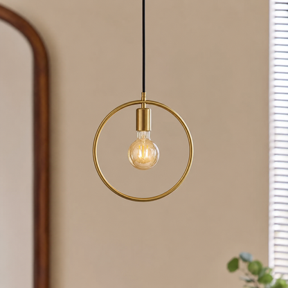 Gold metal ring pendant light with exposed bulb creating warm ambience in contemporary interiors.