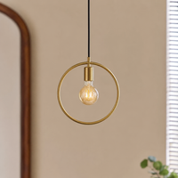 Gold metal ring pendant light with exposed bulb creating warm ambience in contemporary interiors.