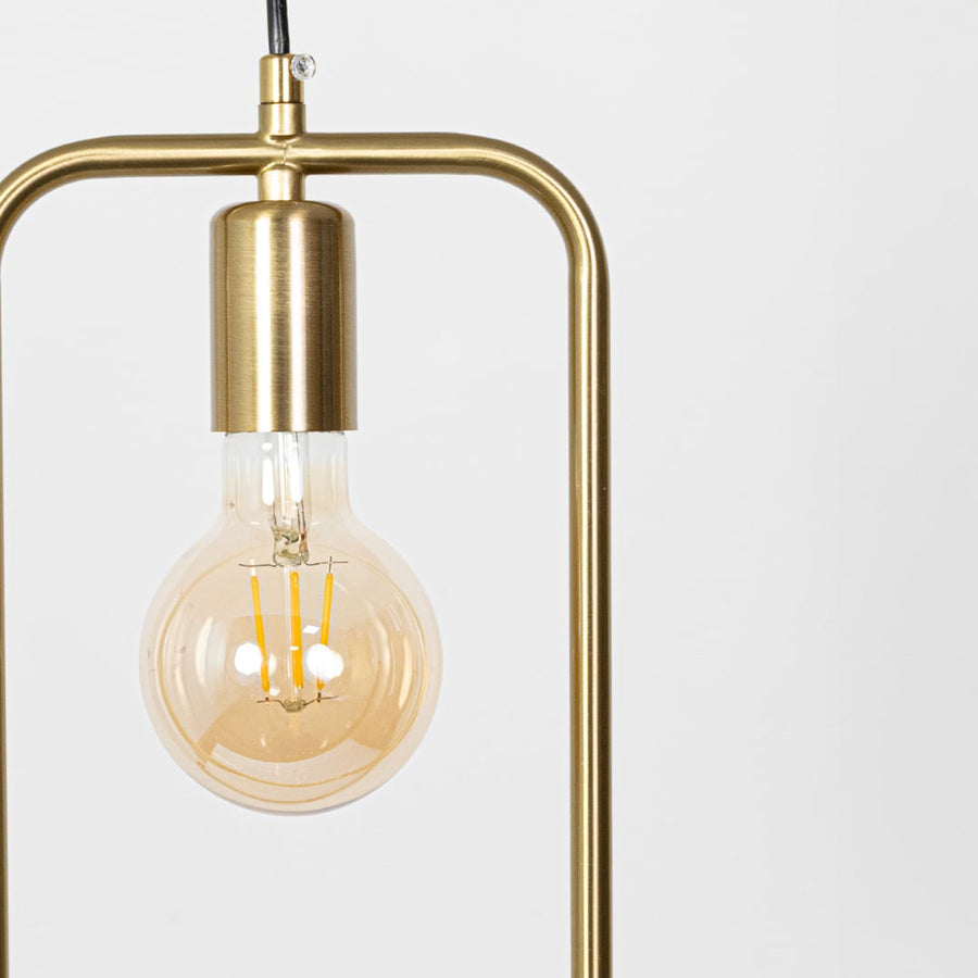 Closeup of amber glass and gold metal pendant light showcasing sleek frame and premium finish.