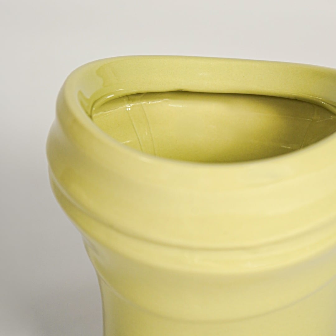 Minimal yellow ceramic decor vase with rounded shape and polished surface designed for tabletop floral arrangements.