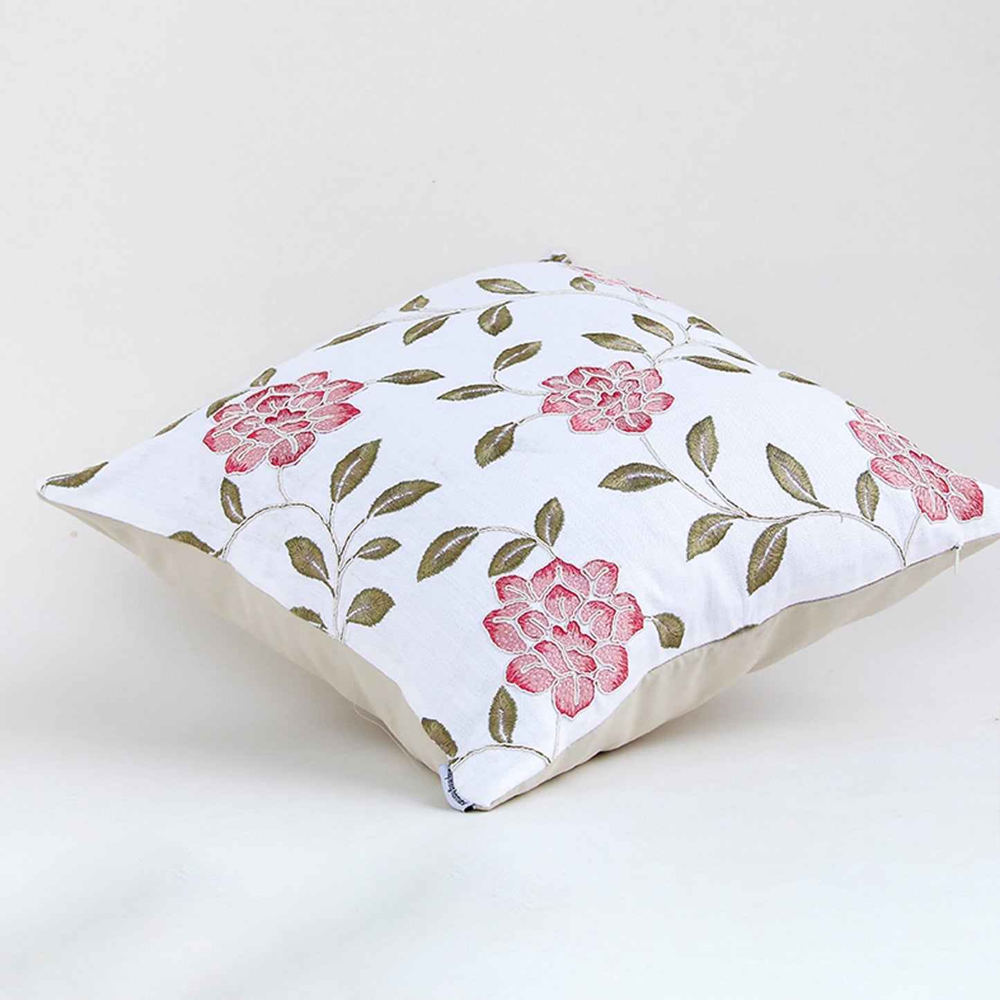Side view of floral cushion cover with pink rose print leafy accents and soft fabric ideal for sofa decor use.