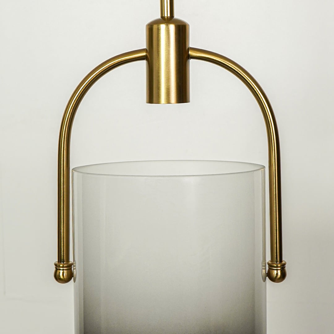 Detailed view of white frosted glass pendant light with curved gold frame and premium finish.