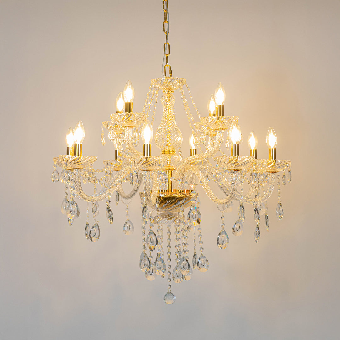 Gold crystal chandelier with illuminated candle bulbs and cascading crystal accents creating luxurious classic ceiling lighting.