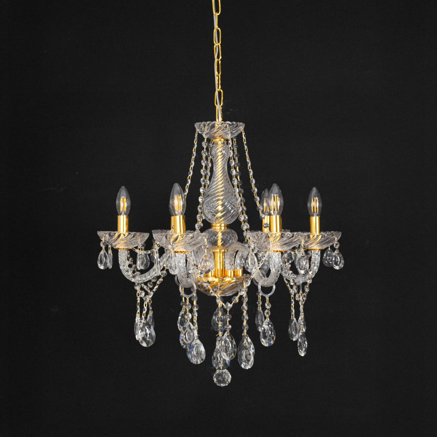 Chandelier with gold frame and crystal details displayed off against black background for modern home style.