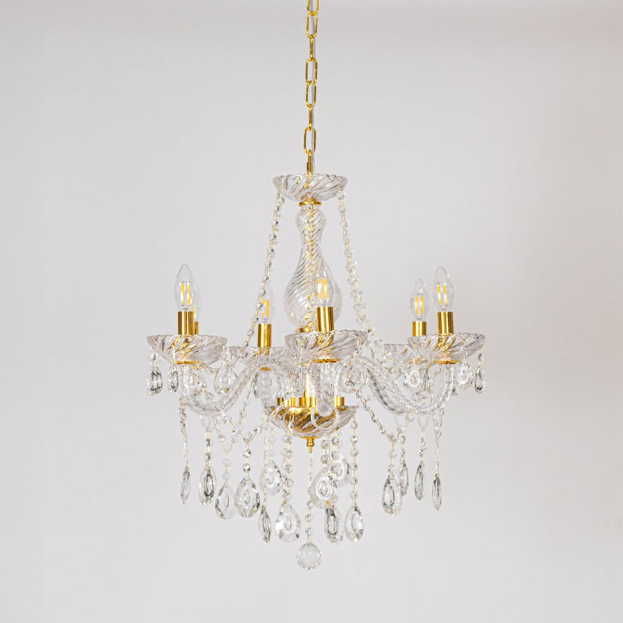 Classic chandelier with gold accents and crystal droplets displayed off on white background for luxury decor.