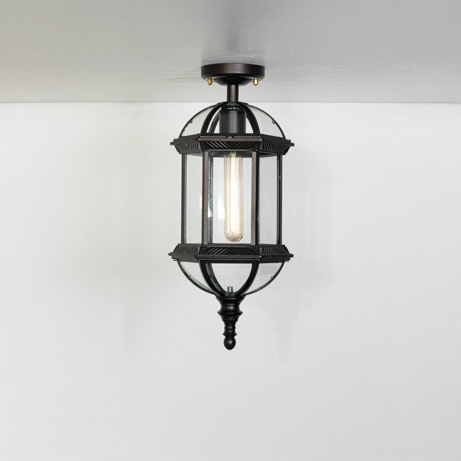 Vintage black metal lantern ceiling light with exposed bulb for classic entryway and traditional decor spaces.