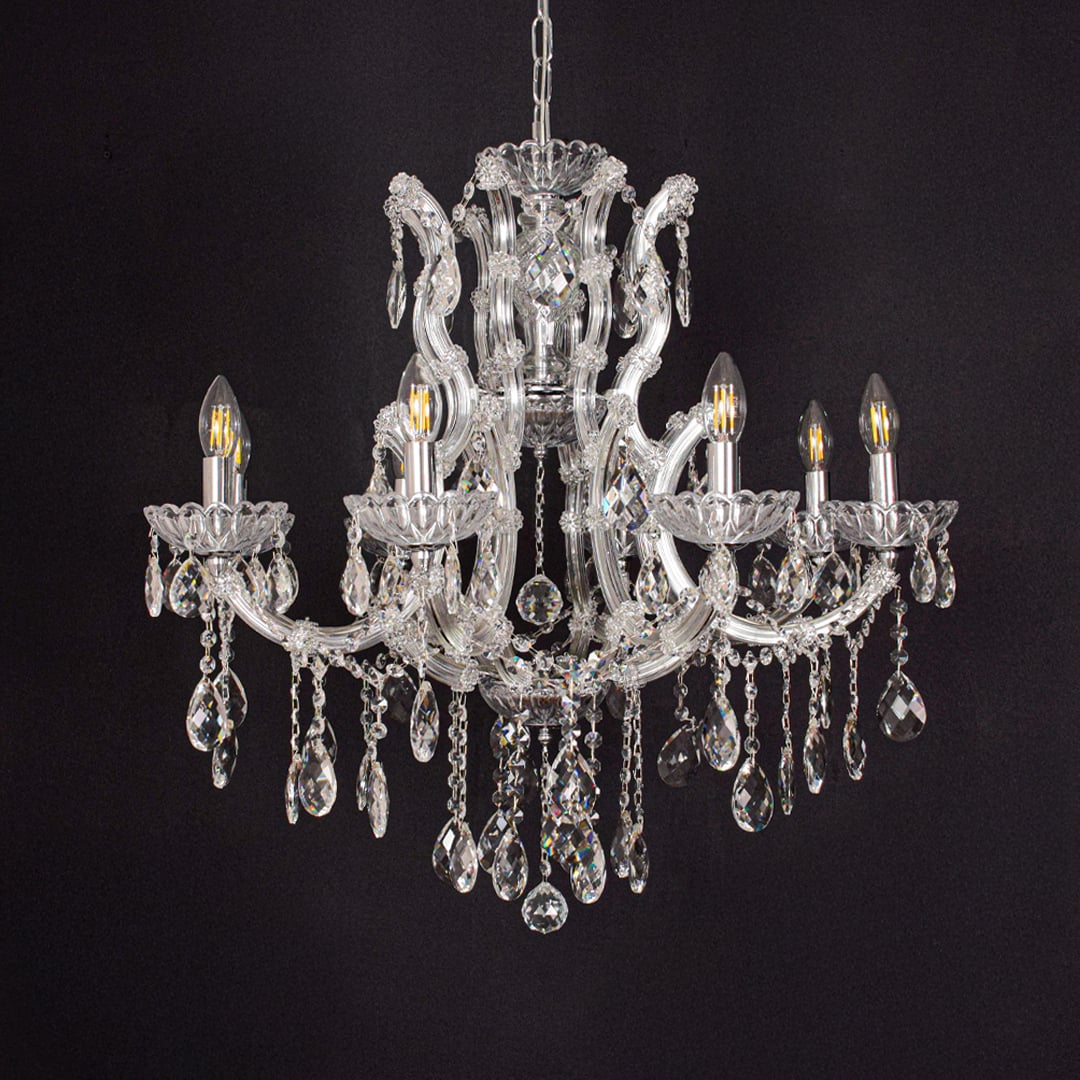 Crystal glass chandelier with chrome accents displayed on black background creating a dramatic elegant decor vibe.