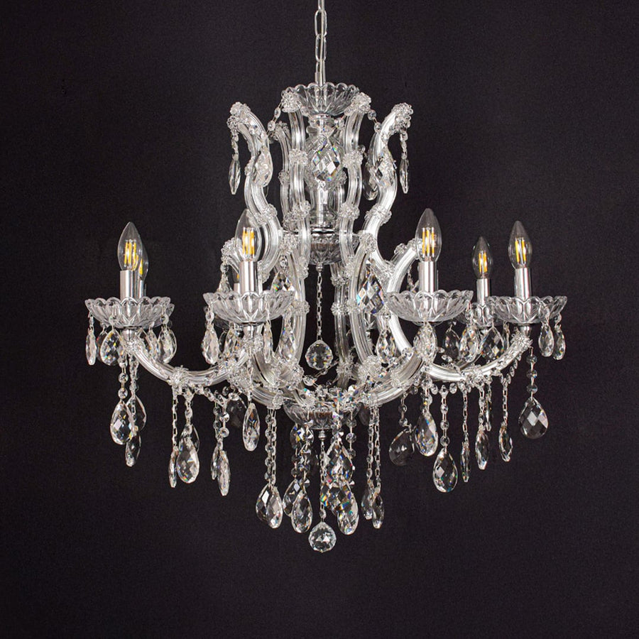 Crystal glass chandelier with chrome accents displayed on black background creating a dramatic elegant decor vibe.