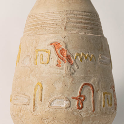 Detailed shot highlighting the artistic engravings and textured clay surface of the hieroglyph vase.