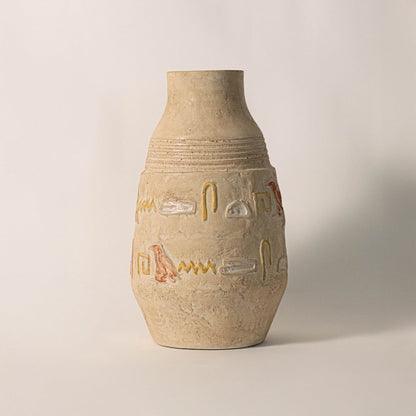 Hieroglyph vase on off-white background surface under soft natural light emphasizing handmade finish and intricate carvings.