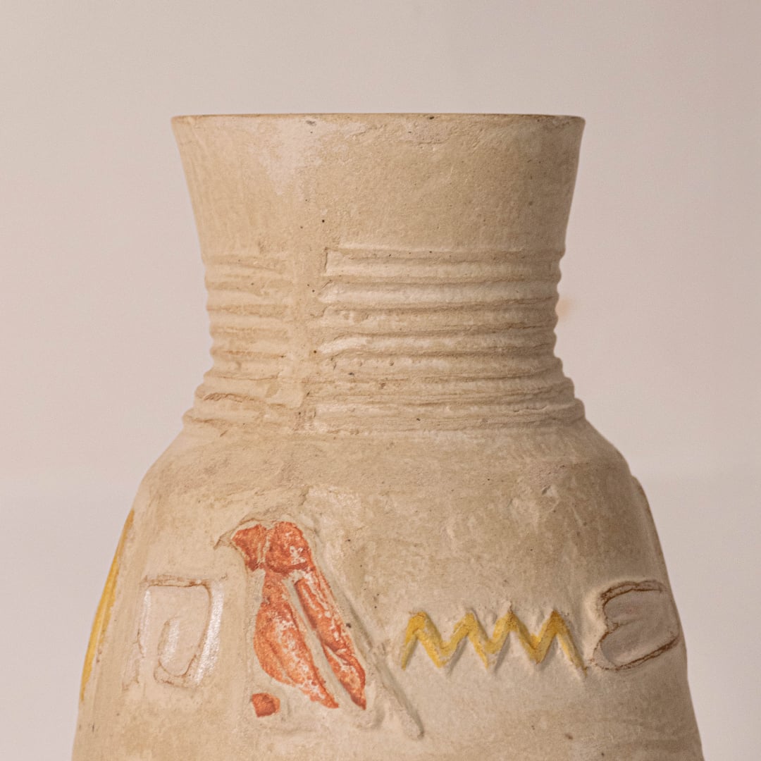Close-up of small hieroglyph vase revealing hand-engraved Egyptian symbols and subtle glaze details.