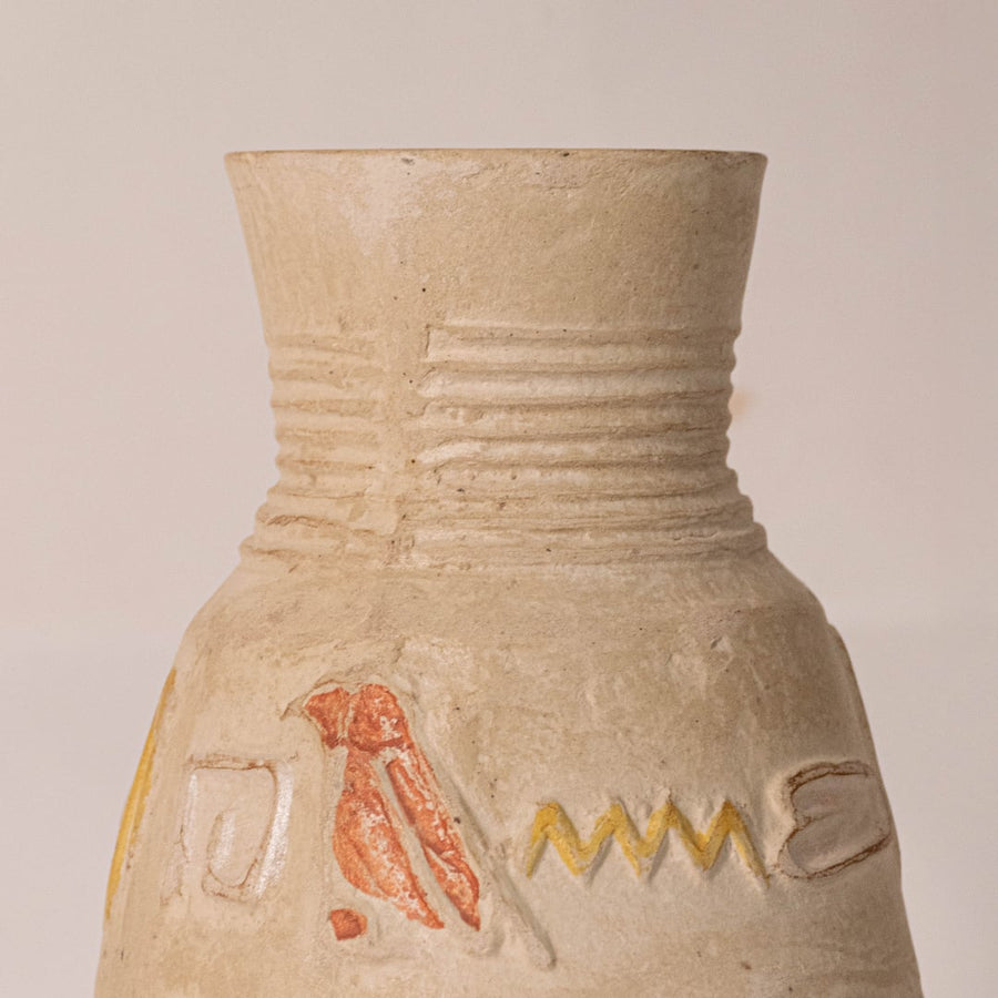 Close-up of small hieroglyph vase revealing hand-engraved Egyptian symbols and subtle glaze details.