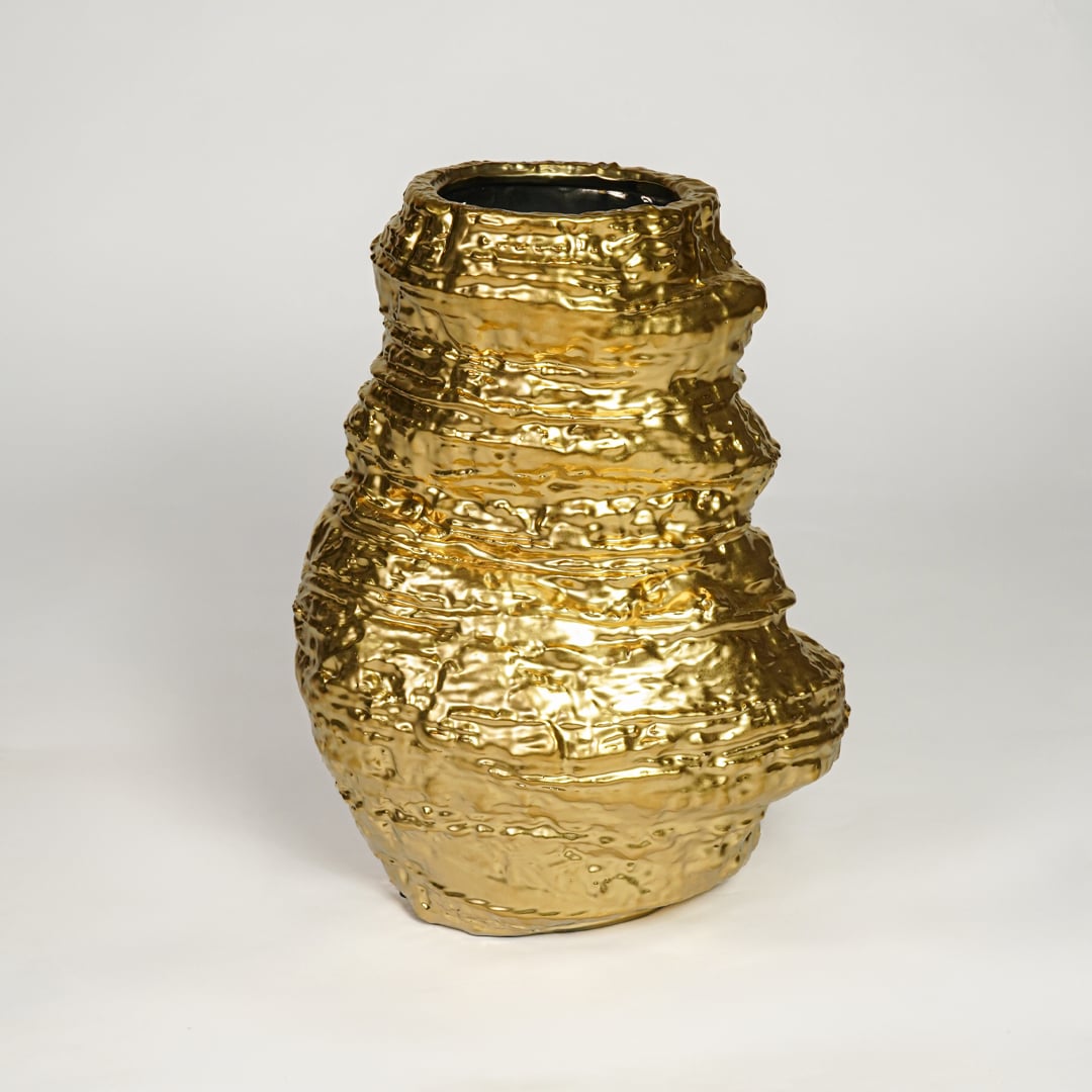 Contemporary gold metal statement vase with artistic hammered finish for luxury home decor styling.