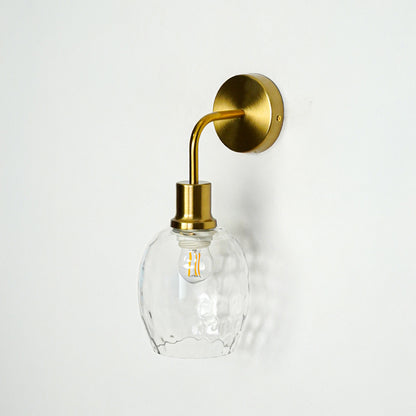 Modern gold metal wall light with textured glass shade for elegant bedroom hallway and living room decor styling.