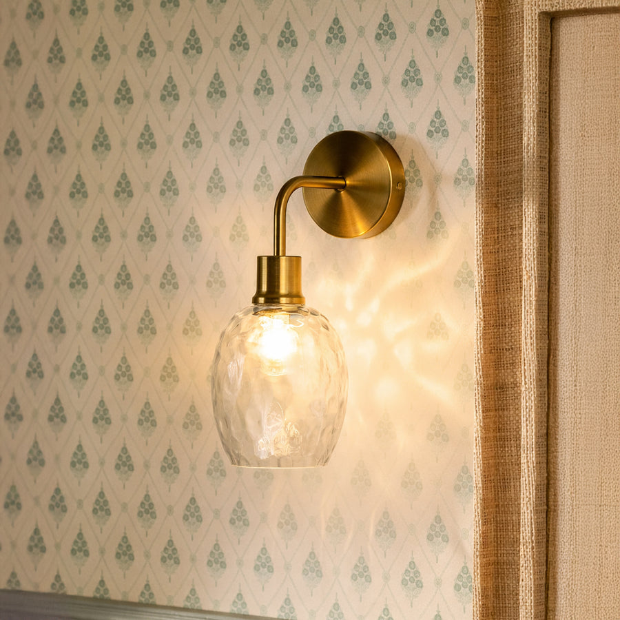 Elegant gold metal wall light with textured glass shade for luxury bedroom hallway and ambient decor styling.