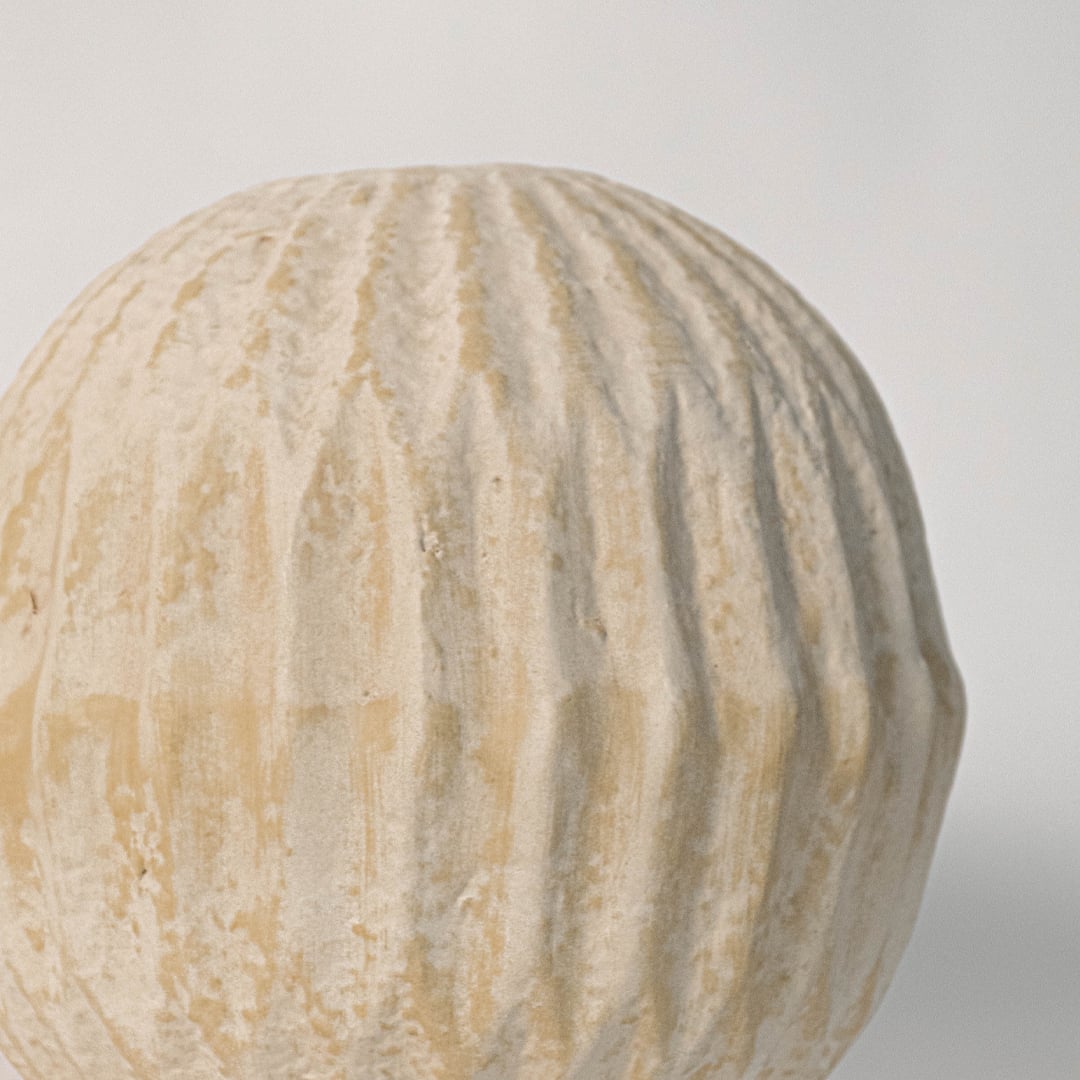 Close up of round textured vase revealing detailed ribbed pattern and fine handmade ceramic texture.