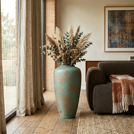 Tall rustic turquoise and bronze floor vase with dried grass for elegant luxury home decor and interior styling.
