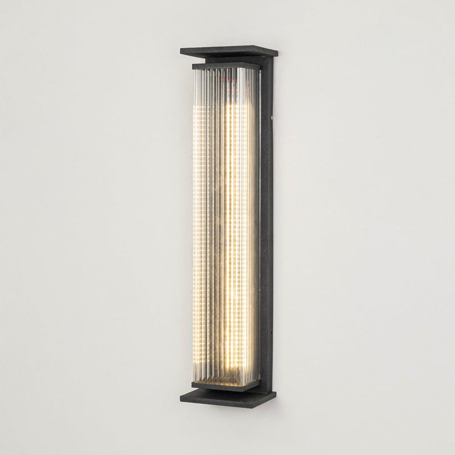 Modern outdoor wall light in black metal with ribbed diffuser displayed on white background highlighting sleek exterior lighting design.