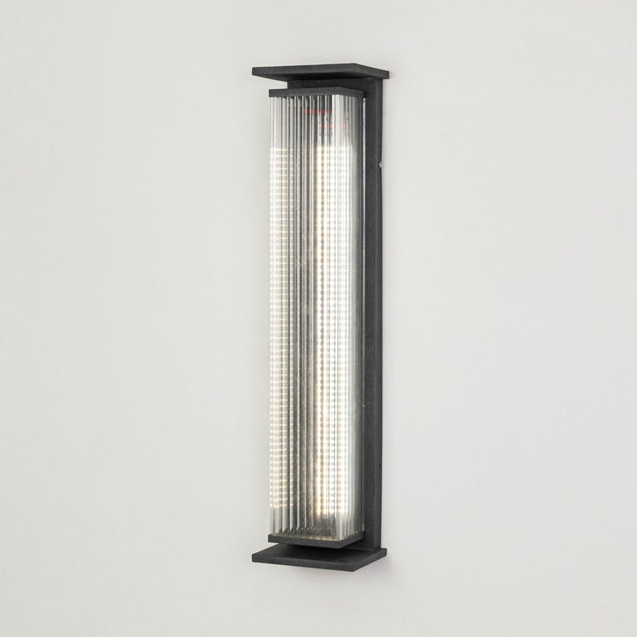 Modern outdoor wall light in black metal with ribbed diffuser displayed on white background highlighting sleek exterior lighting design.