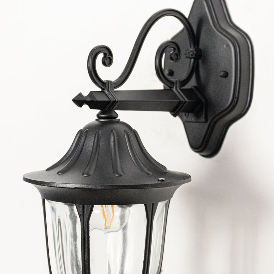 Closeup view of black metal outdoor lantern wall light highlighting clear glass panels sturdy frame and classic exterior lighting design.
