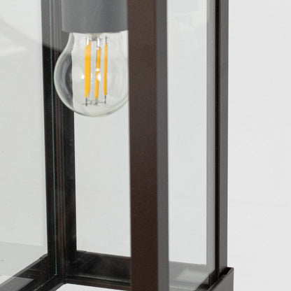 Closeup view of rectangular hanging lantern light showing bulb and sleek brown frame details.