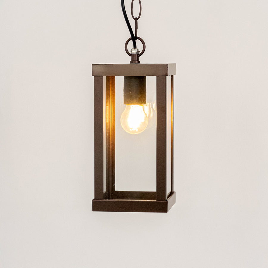 Modern black metal box hanging lantern light with warm glow for stylish outdoor ceiling decor.