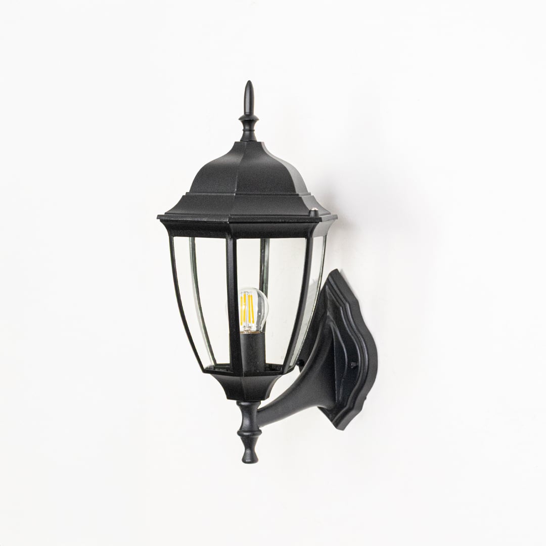 Black metal outdoor wall lantern shown unlit on white background highlighting classic design glass panels and exterior Decor appeal.
