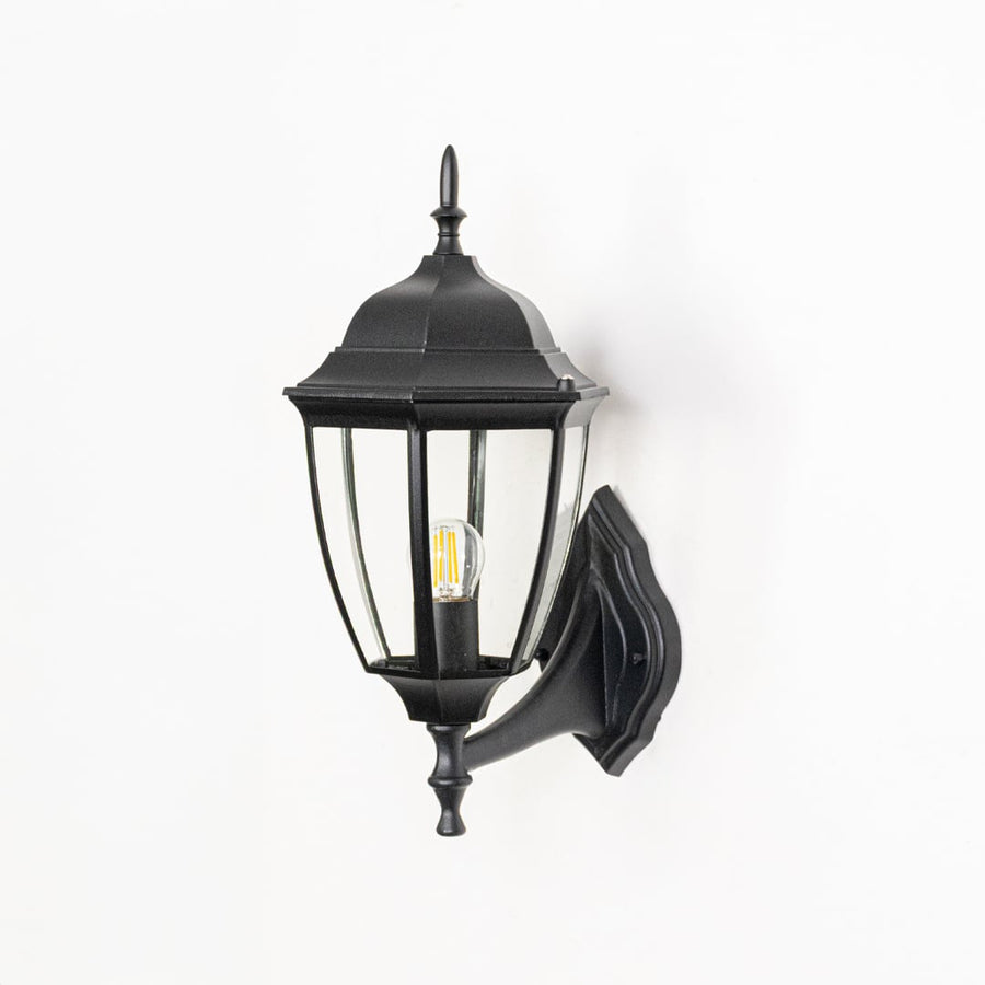 Black metal outdoor wall lantern shown unlit on white background highlighting classic design glass panels and exterior Decor appeal.