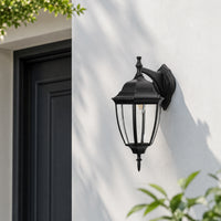 Classic black metal outdoor wall lantern with clear glass for porch entrance garden and exterior walls with warm lighting.