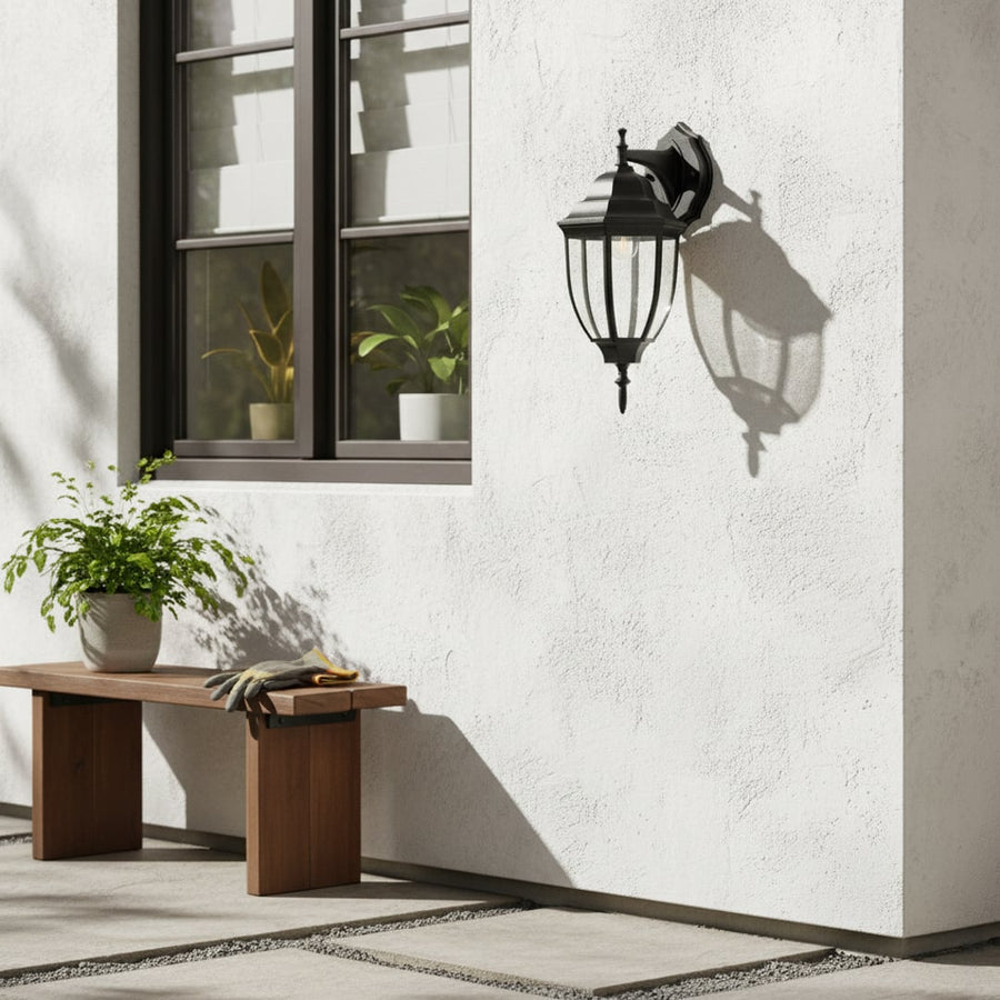 Outdoor wall light with classic black lantern design installed on modern exterior wall enhancing daytime facade with elegant shadow play and entryway styling appeal.