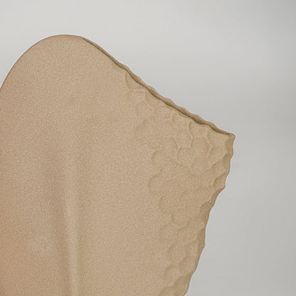 Closeup beige ceramic textured designer vase surface detail modern artistic decorative flower vase for table shelf home decor styling.