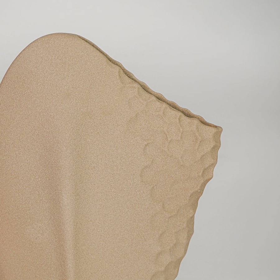 Closeup beige ceramic textured designer vase surface detail modern artistic decorative flower vase for table shelf home decor styling.