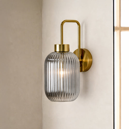 Gold finish wall light with clear ribbed glass shade perfect for modern interior wall decor placement on clean background.