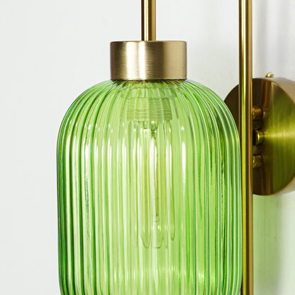 Closeup of gold metal wall light with green ribbed glass shade showcasing detailed texture and premium finish for modern decor styling.