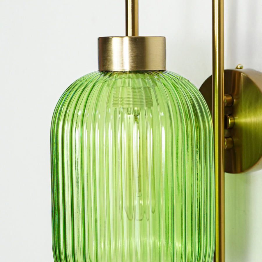 Closeup of gold metal wall light with green ribbed glass shade showcasing detailed texture and premium finish for modern decor styling.