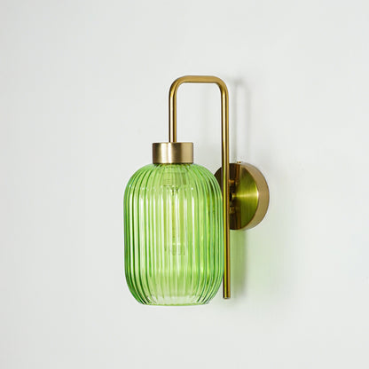 Gold metal wall light with green ribbed glass shade and sleek arm design perfect for modern interior wall decor on clean background.