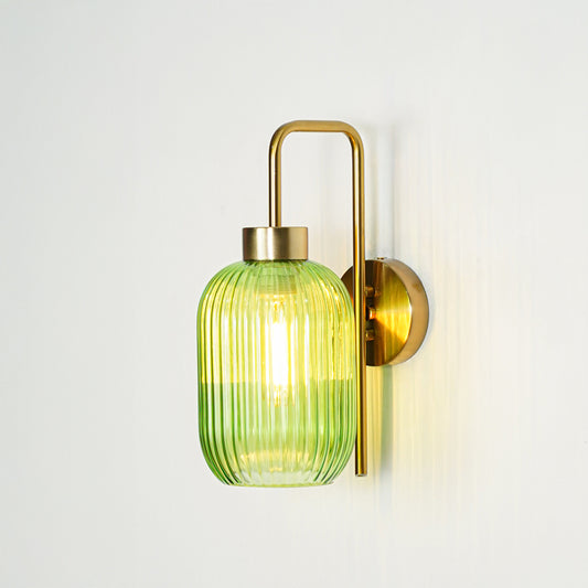 Gold finish wall light with green ribbed glass shade emitting warm ambient glow ideal for bedroom or hallway wall decor placement.