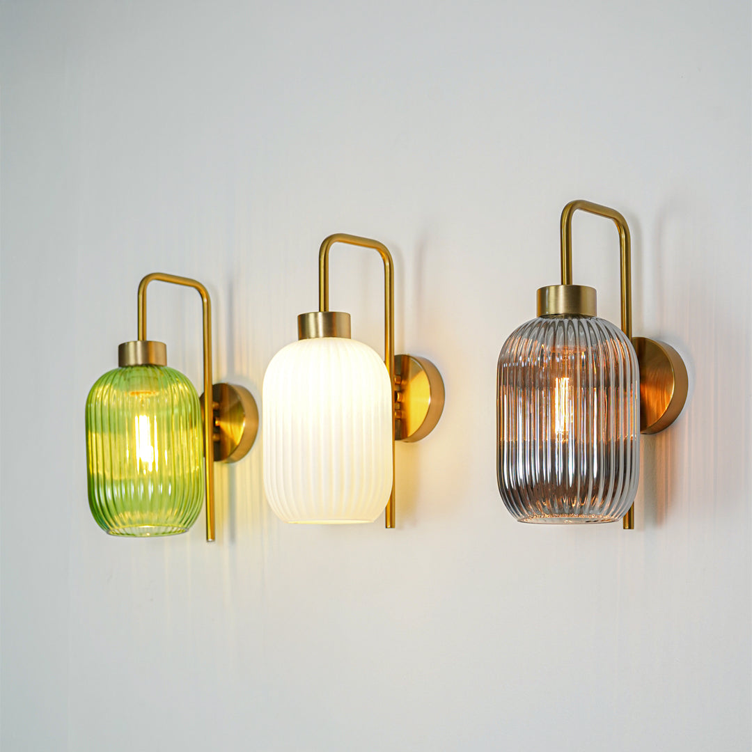 Gold finish wall lights with ribbed glass shades emitting warm ambient glow perfect for elegant interior wall decor styling.