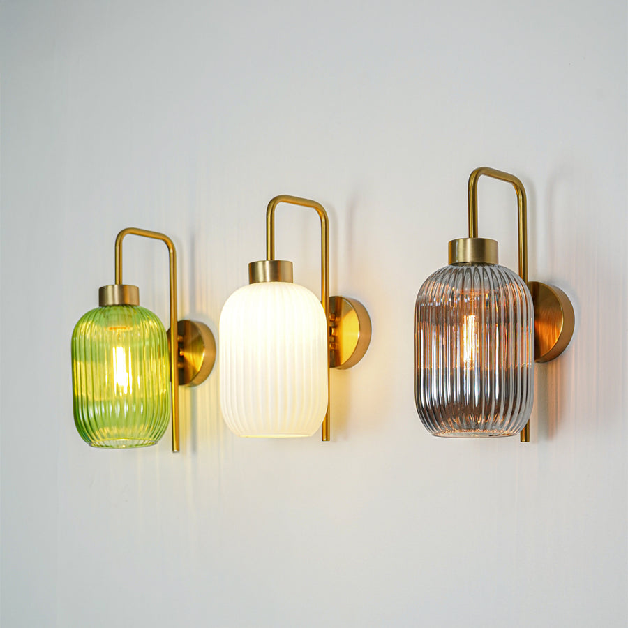 Gold finish wall lights with ribbed glass shades emitting warm ambient glow ideal for elegant interior wall decor styling.