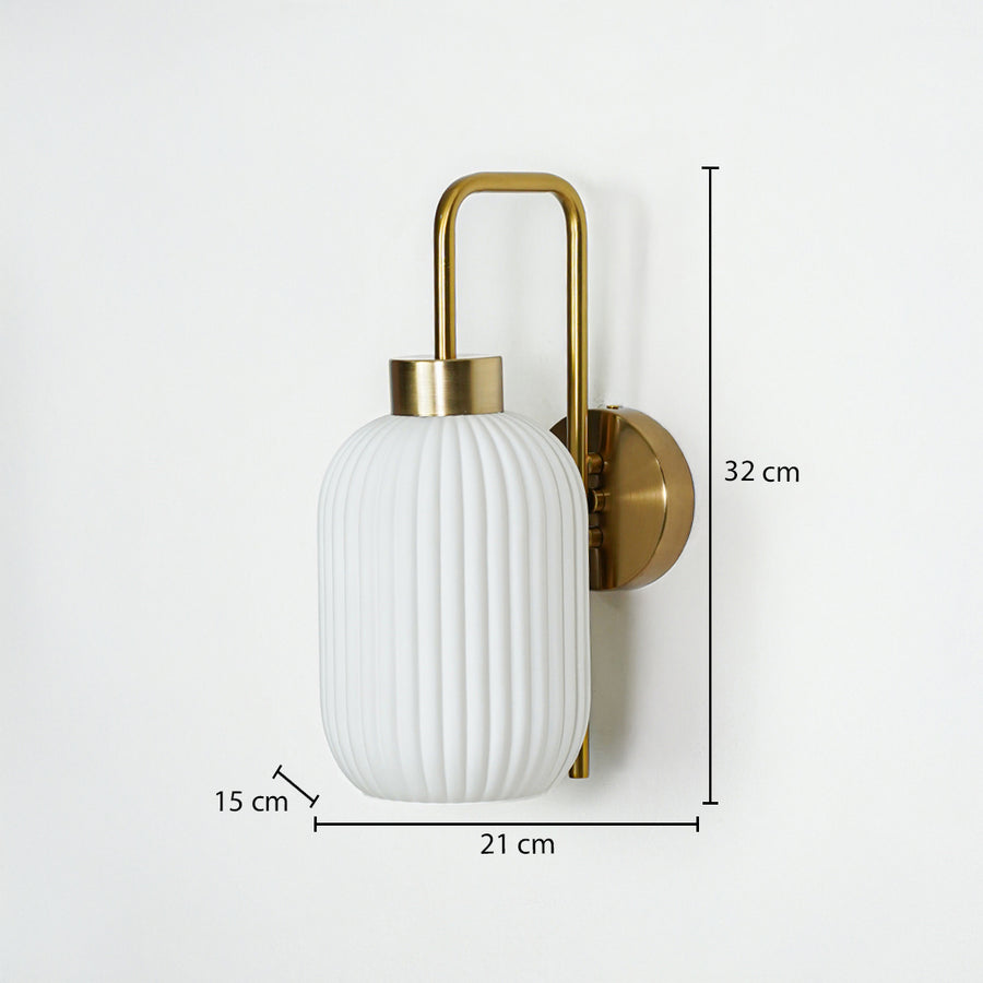 Gold metal wall light with white ribbed glass shade sized 32 cm height 21 cm width and 15 cm depth ideal for wall decor.