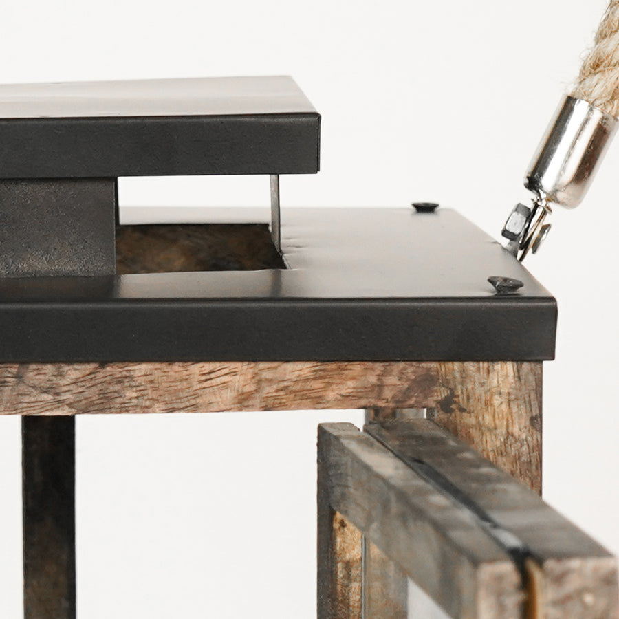 Close-up of a rustic wooden table with metal legs and a lamp.