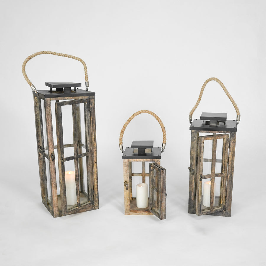 Three wooden lanterns with candles inside on a white background