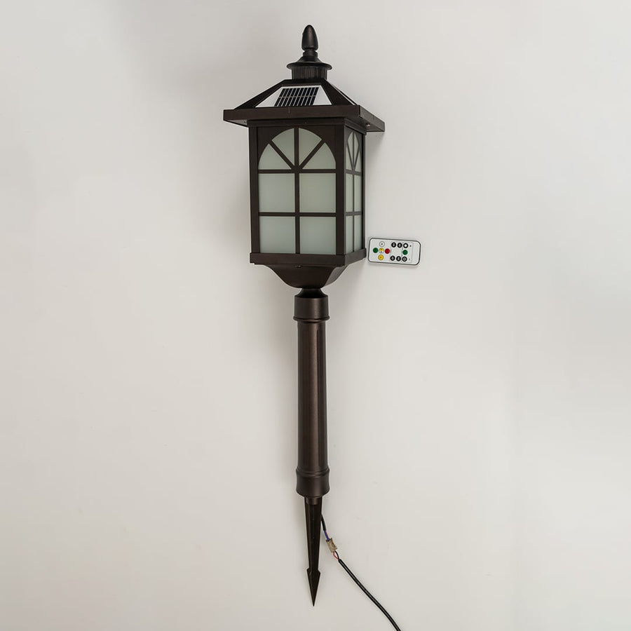 A bronze solar pathway lantern with the light off displayed on a white background emphasizing its tall stake structure frosted panels and decorative classic top.
