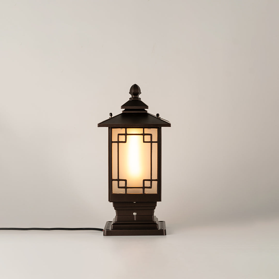 Black outdoor gate light with warm glowing bulb for stylish exterior decor styling use.