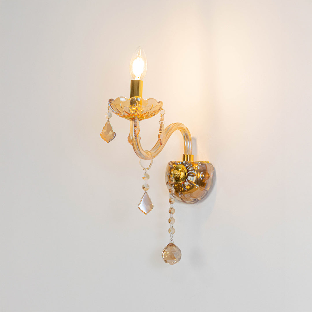 Modern crystal wall light in gold finish with hanging crystals for bedroom or living decor lighting white background.