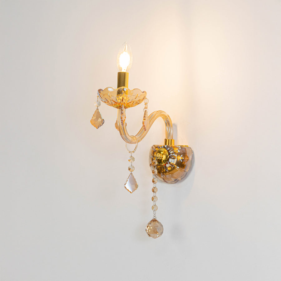 Modern crystal wall light in gold finish with hanging crystals for bedroom or living decor lighting white background.