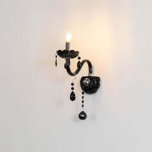 Decorative crystal wall light in black finish with hanging crystals for bedroom or living decor lighting white background.