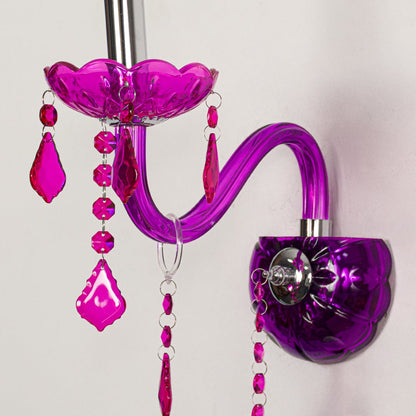 Closeup of pink wall light showing curved acrylic arm and bold crystal drops for eye catching modern interior lighting.