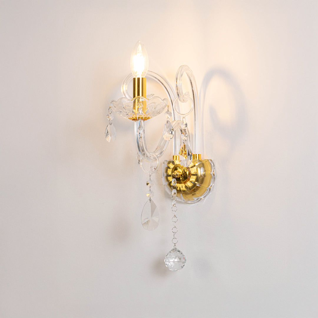 Modern crystal wall light in gold finish with hanging crystals for bedroom or living decor lighting white background.